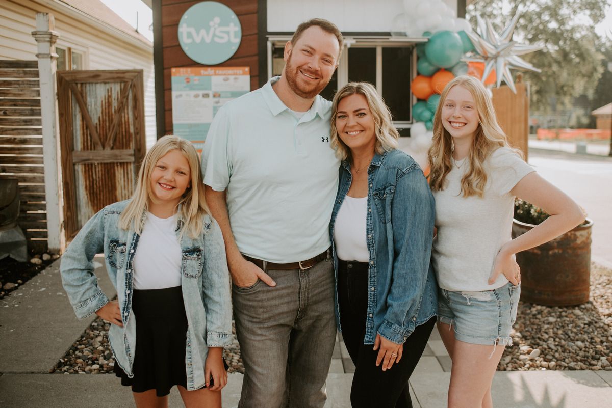 The Simmons family standing in front of their walk-up soda shop