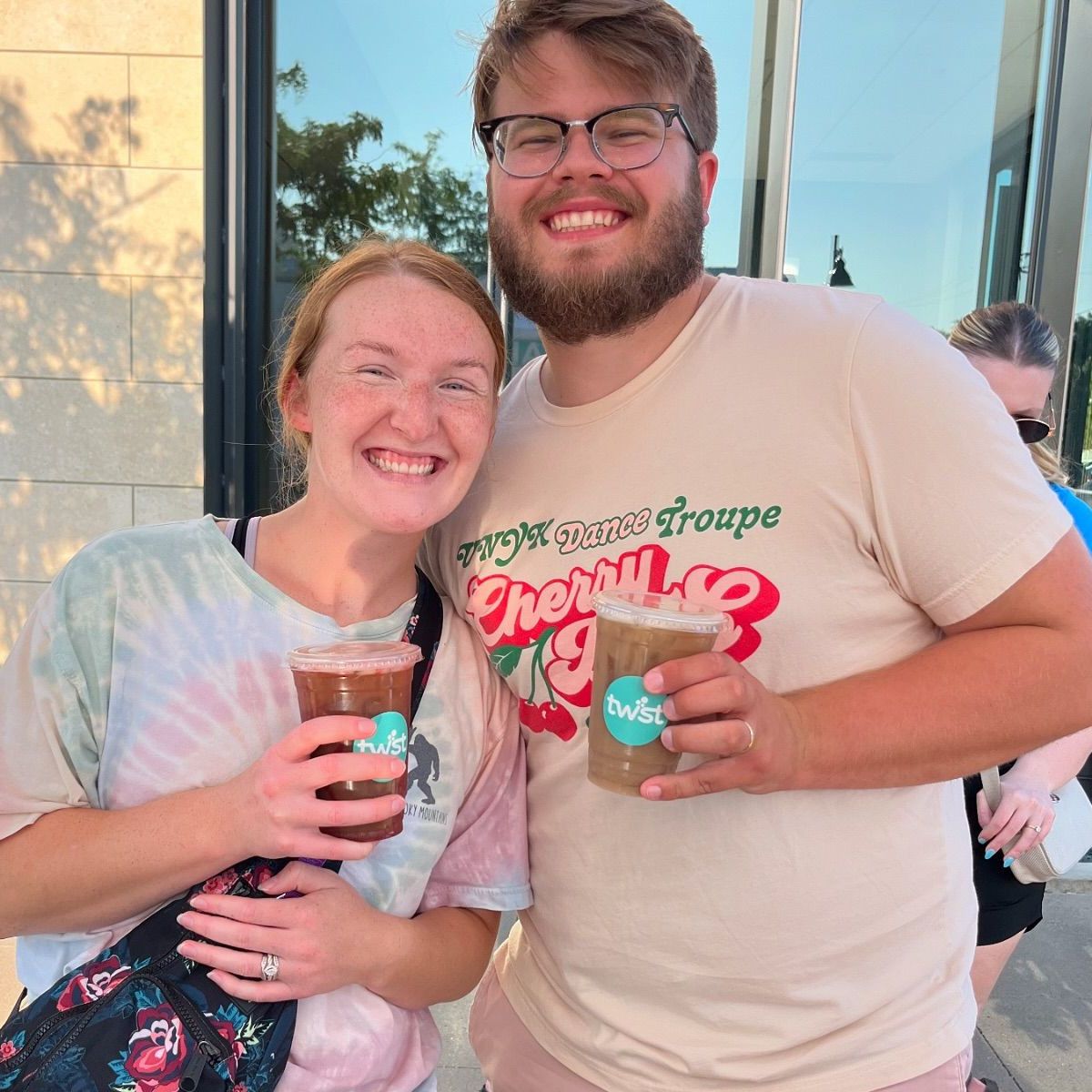 2 smiling kids with their Twist drinks in front of a inflatable kid's playground