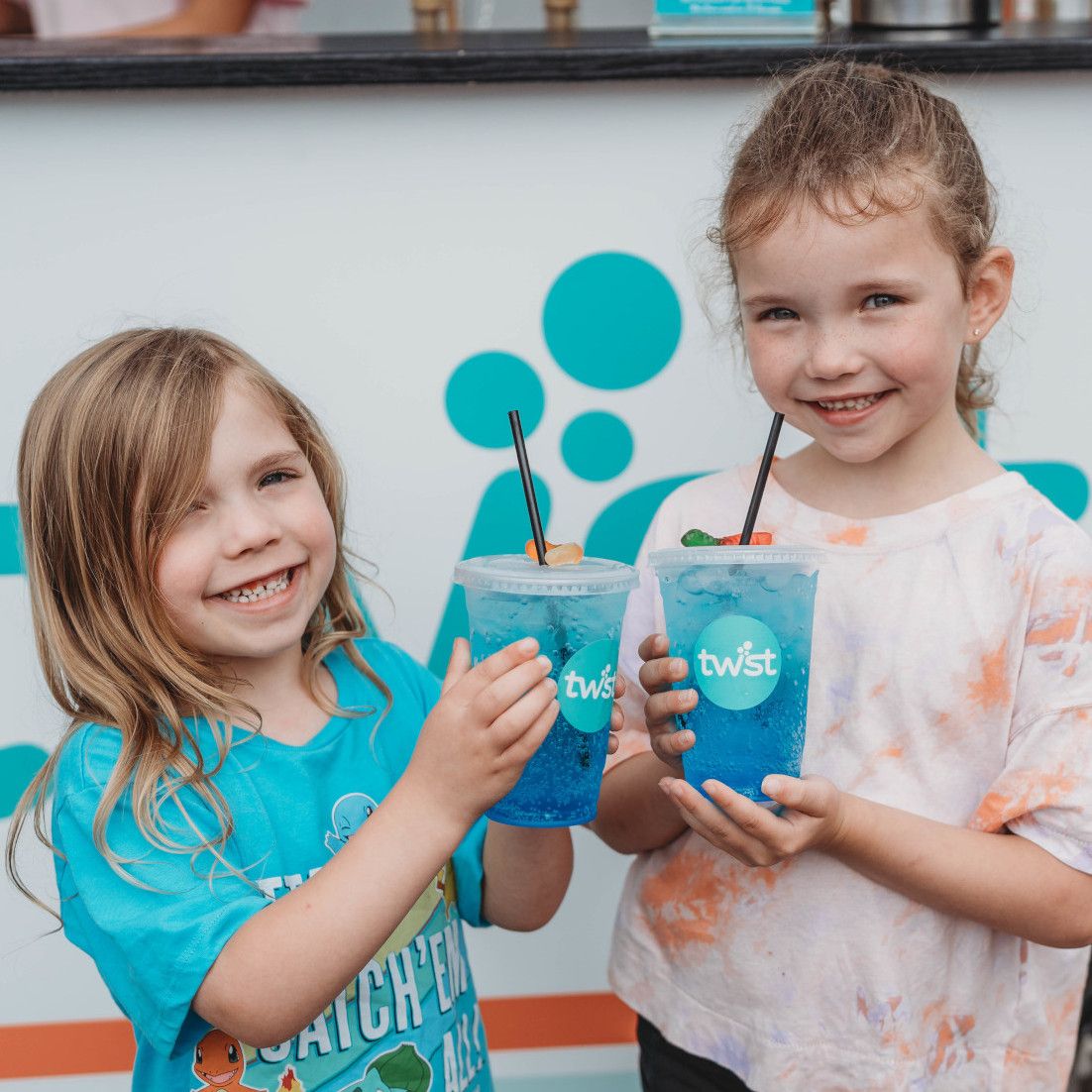 2 smiling kids with blue Twist drinks